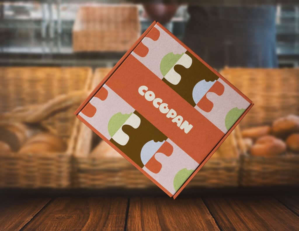Cocopan packaging showcasing colorful brand identity design in a bakery setting with baskets of bread in the background.