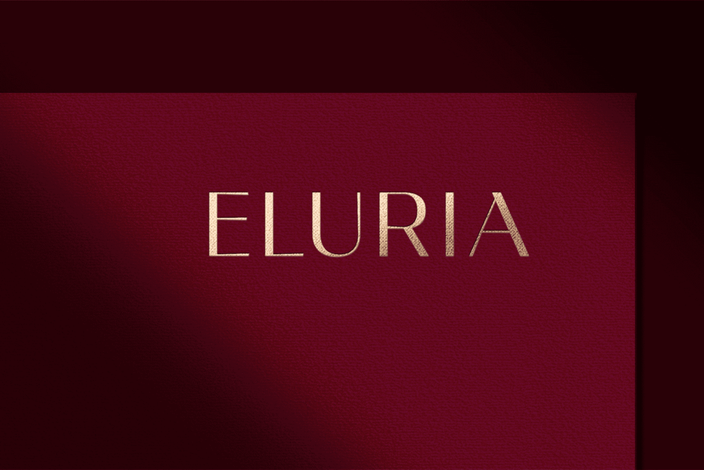 Eluria branding design on burgundy background showcasing elegant visual identity with gold typography.