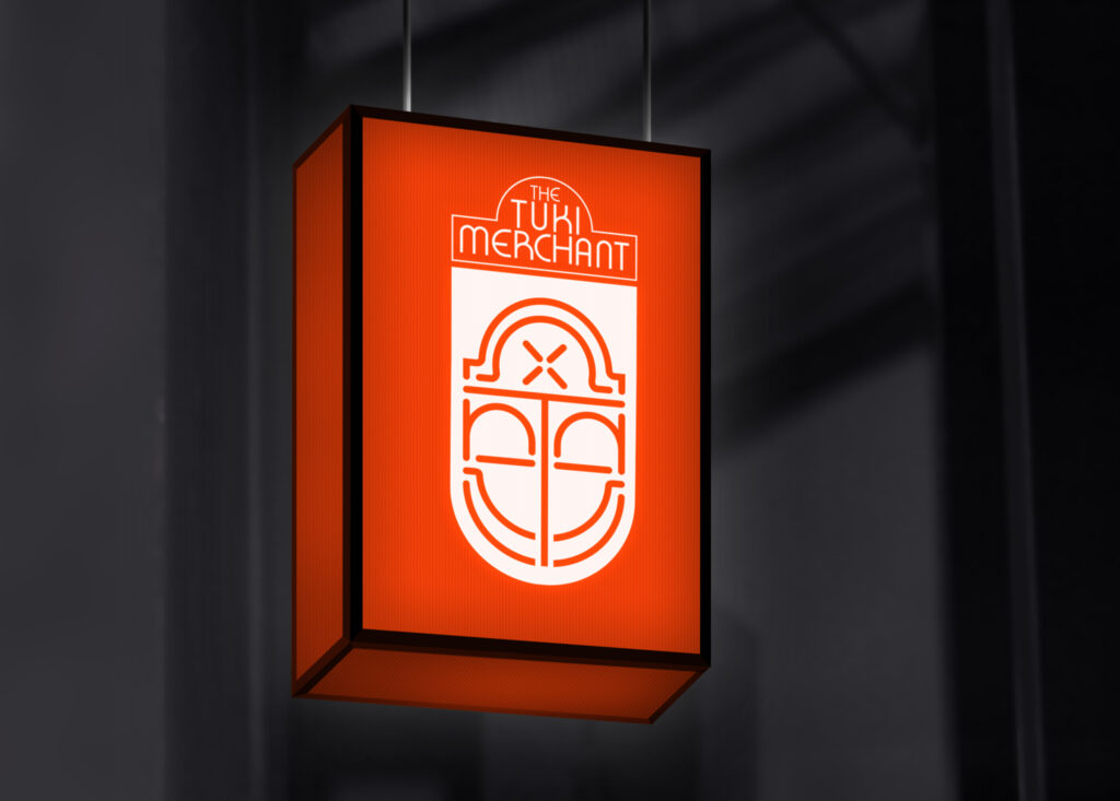 Red illuminated signage for The Tuki Merchant featuring bold text and abstract icon, highlighting brand identity design.