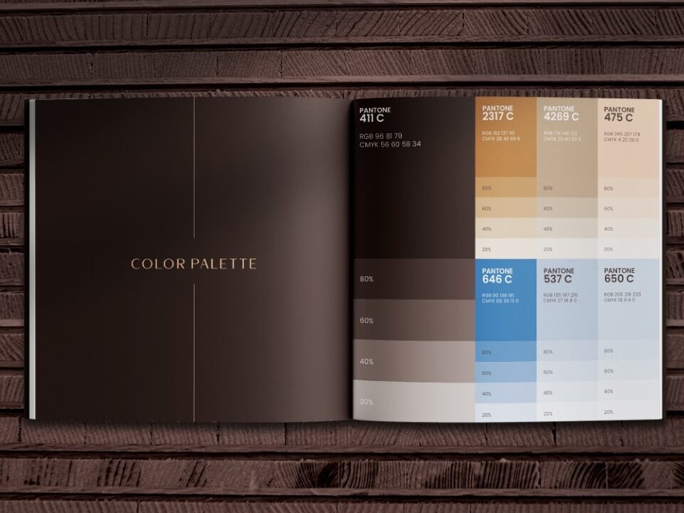 Color palette booklet showcasing Pantone shades for brand identity on dark wooden background.