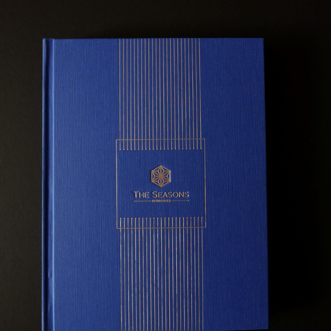 The Seasons Residences branding with elegant blue cover and gold geometric design, showcasing visual identity.