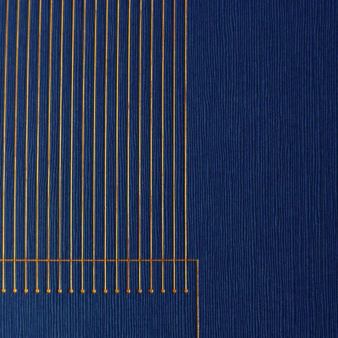 Blue textured background with vertical and horizontal gold lines, showcasing modern visual identity and branding design.